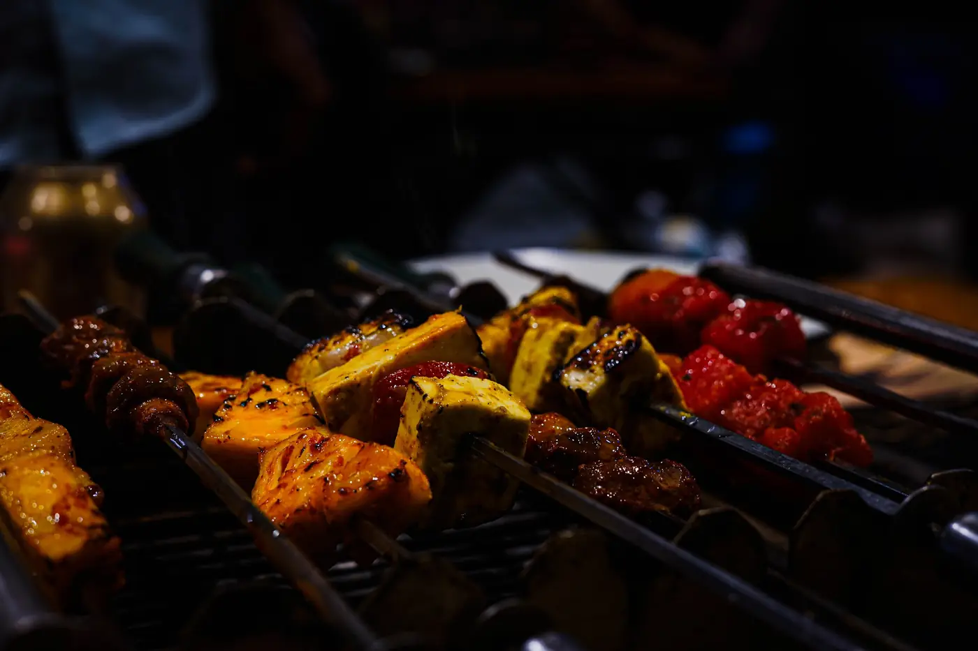 Chicken skewers grilling over charcoal